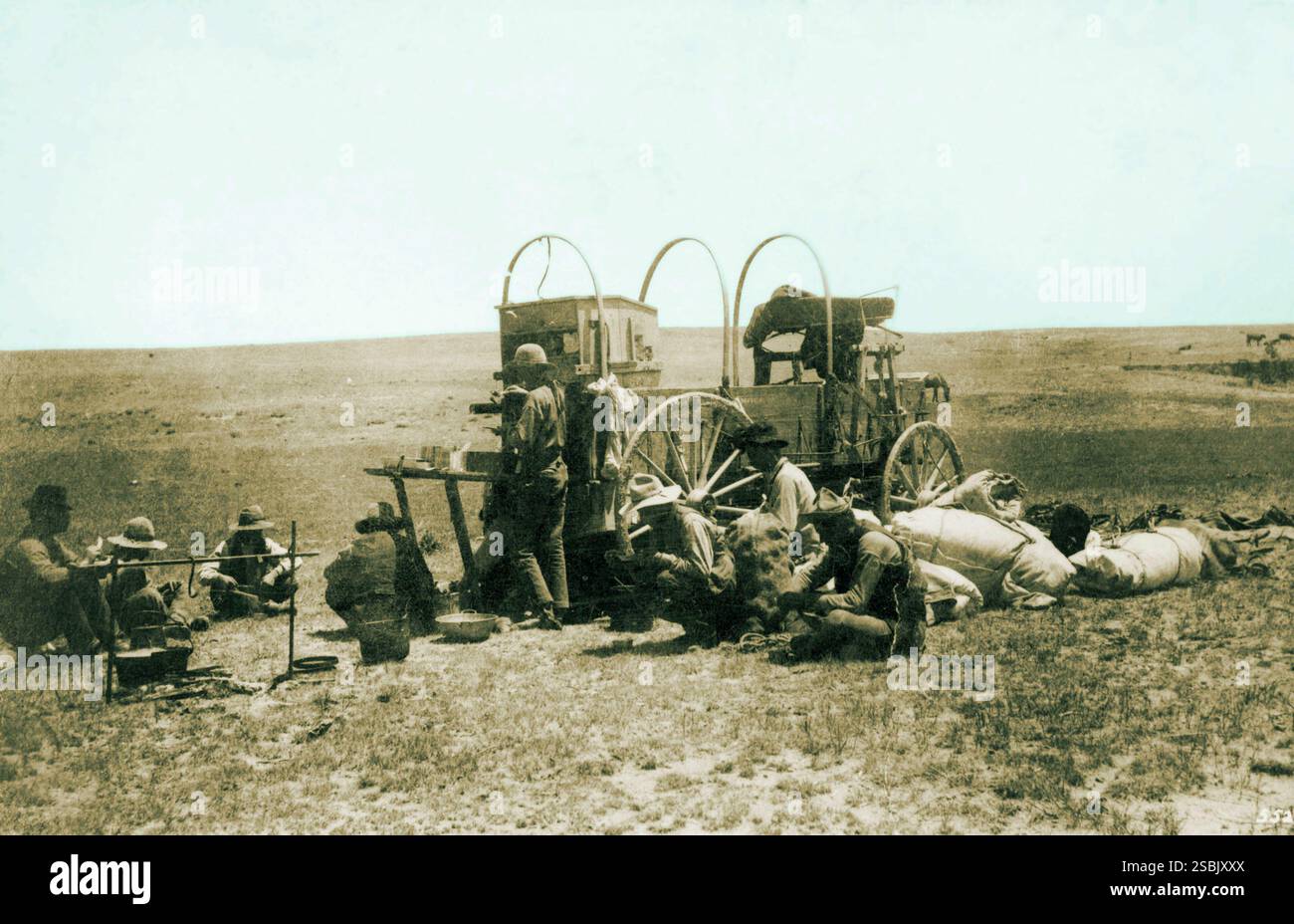 Un carro mandrino durante il raduno primaverile a Iliff Ranch, Colorado, 1887. Un carro a mandrino o carro a mandrino è un carro trainato da cavalli che opera come cucina mobile da campo. Il caposquadra, A.H. Allen, è appoggiato al carro. Foto Stock