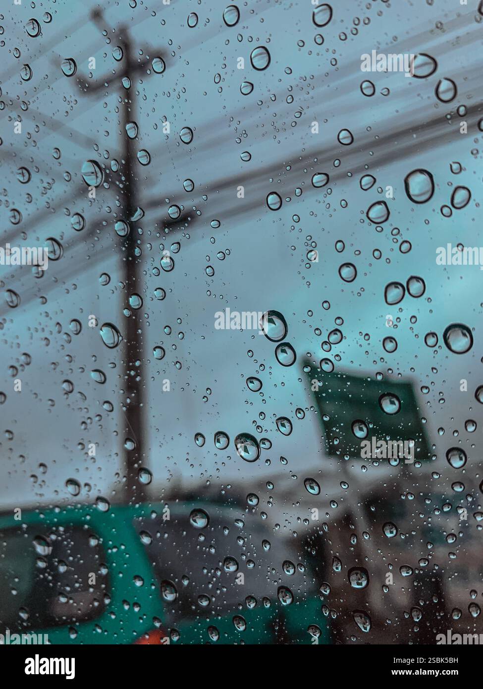 La pioggia cade sul finestrino dell'auto durante il traffico - Immagine stock catturata con smartphone