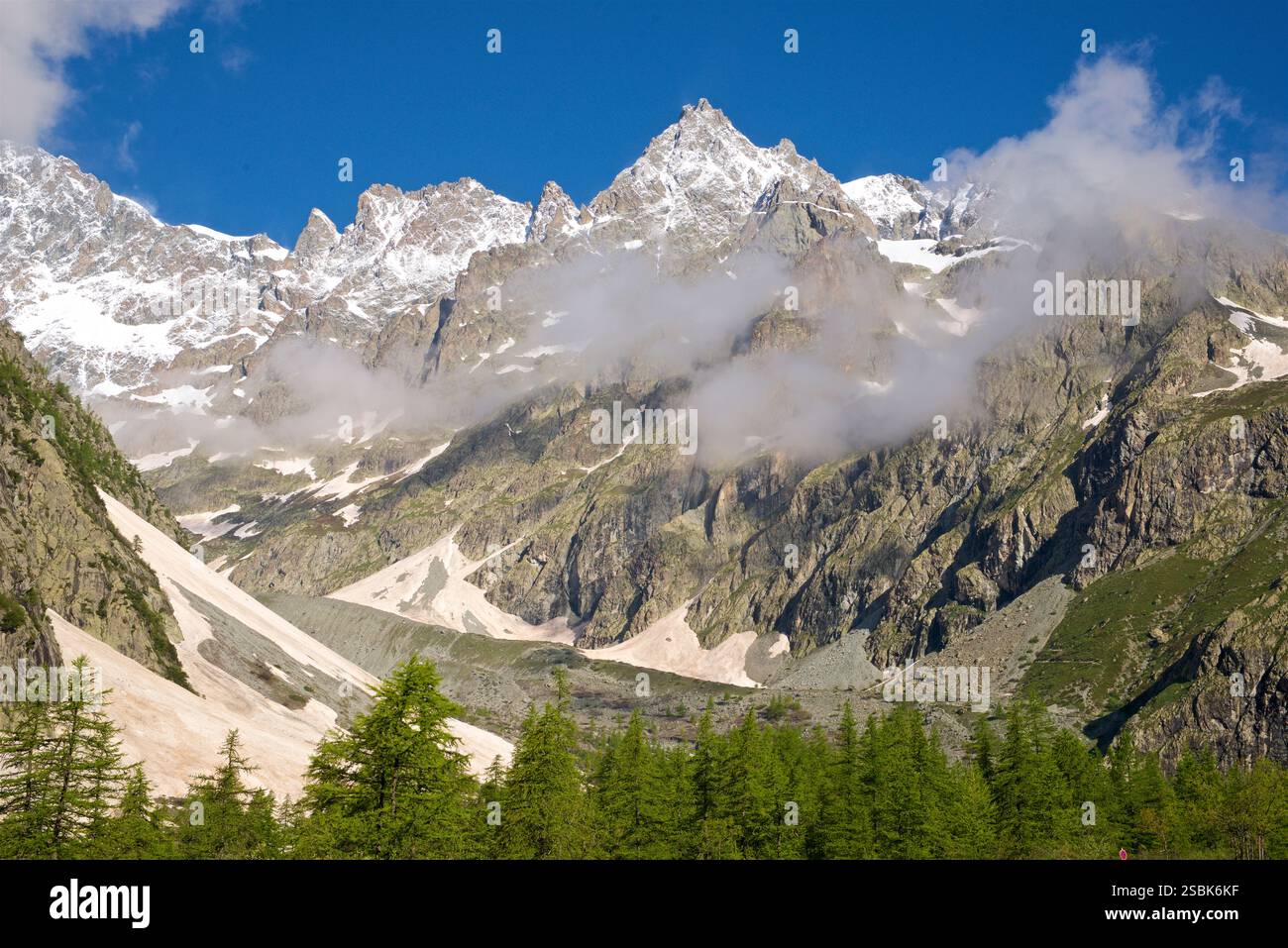 La vetta della foto è "le Pelvoux" nel massiccio degli Écrins, in Francia. Le Pelvoux è una vetta prominente situata nelle Alpi del Delfinato, vicino al villaggio di Ailefroide in Francia. Ha diverse cime, la più alta è la Pointe Puiseux, che si erge a 3.946 metri (12.946 piedi). L'aspetto frastagliato e aspro della vetta e del paesaggio circostante, combinato con la vista dal Pré de Madame Carle, sono indicativi di le Pelvoux. È uno dei picchi più riconosciuti della regione di Écrins. Foto Stock