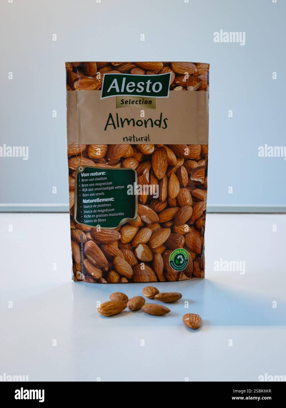 Mandorle di marca Alesto in una borsa, alcune mandorle fuori dalla borsa sul tavolo Foto Stock