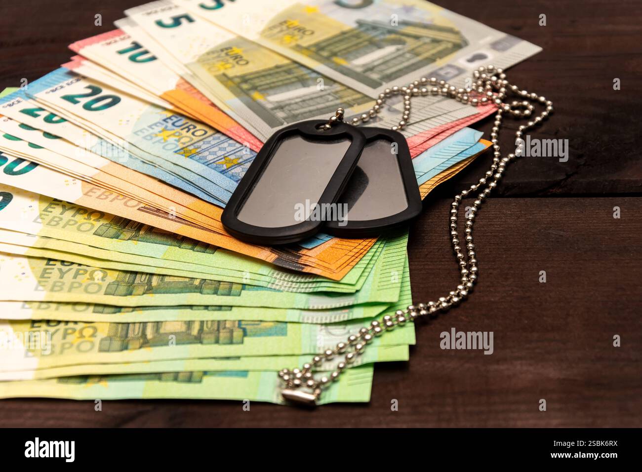 Gettone militare metallico contro le banconote in euro - il concetto di pagamenti militari e sostegno economico Foto Stock