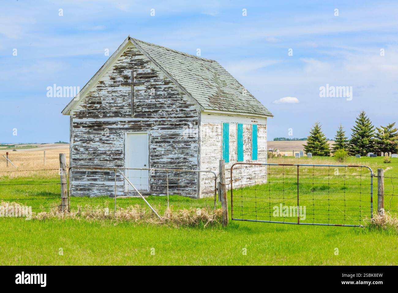 Edificio bianco con tetto blu. Sul tetto mancano le zampe. L'edificio è circondato da una recinzione Foto Stock