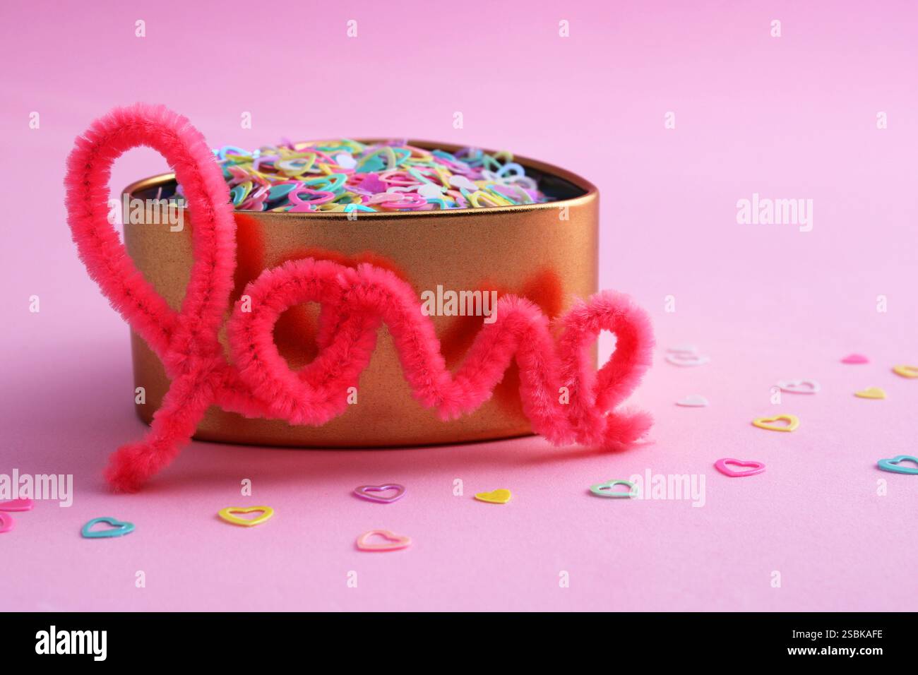 Parola d'amore accanto al contenitore dorato a forma di cuore Foto Stock