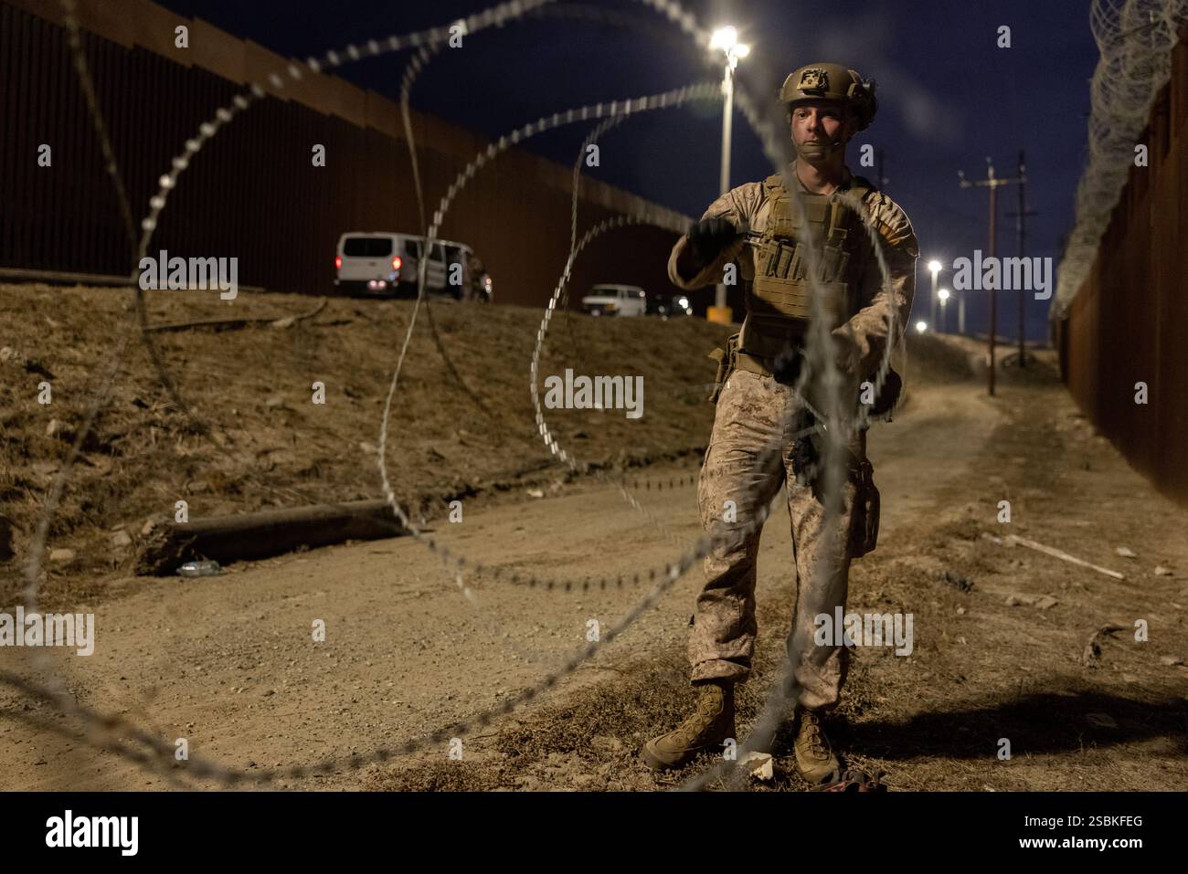 Un Marine degli Stati Uniti con il 1st Combat Engineer Battalion, 1st Marine Division, srotola il filo della concertina lungo il confine meridionale vicino a San Ysidro, California, 25 gennaio 2025. Il comando del Nord degli Stati Uniti sta collaborando con il Dipartimento della sicurezza interna con l'installazione di barriere fisiche temporanee per aggiungere ulteriore sicurezza che limiterà i valichi di frontiera illegali. (Foto del corpo dei Marines degli Stati Uniti del sergente Kyle Chan) Foto Stock