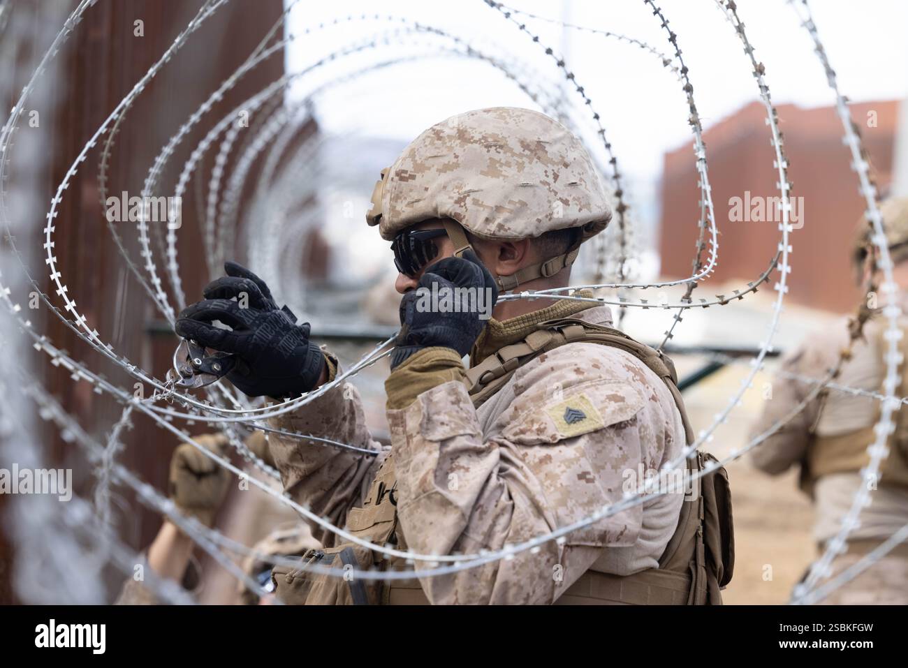 Un Marine degli Stati Uniti con 1st Combat Engineer Battalion, 1st Marine Division, regola il filo di concertina lungo il muro di confine meridionale vicino a San Ysidro, California, 27 gennaio 2025. Il comando del Nord degli Stati Uniti sta collaborando con il Dipartimento per la sicurezza interna con l'installazione di barriere fisiche per aggiungere ulteriore sicurezza che limiterà i valichi di frontiera illegali. (Foto del corpo dei Marines degli Stati Uniti di Lance Cpl. Caleb Goodwin) Foto Stock