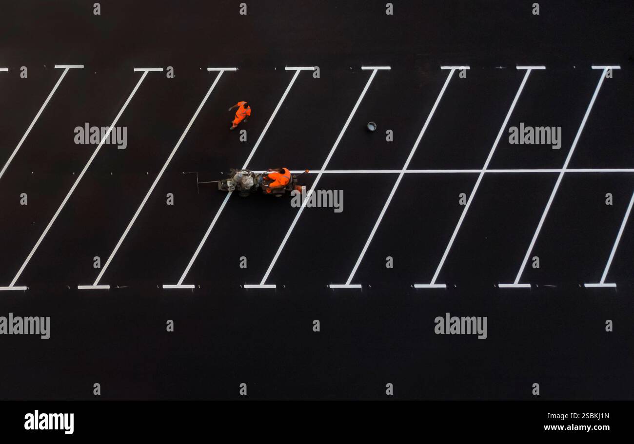 I lavoratori che dipingono un parcheggio gratuito. Vista aerea Foto Stock