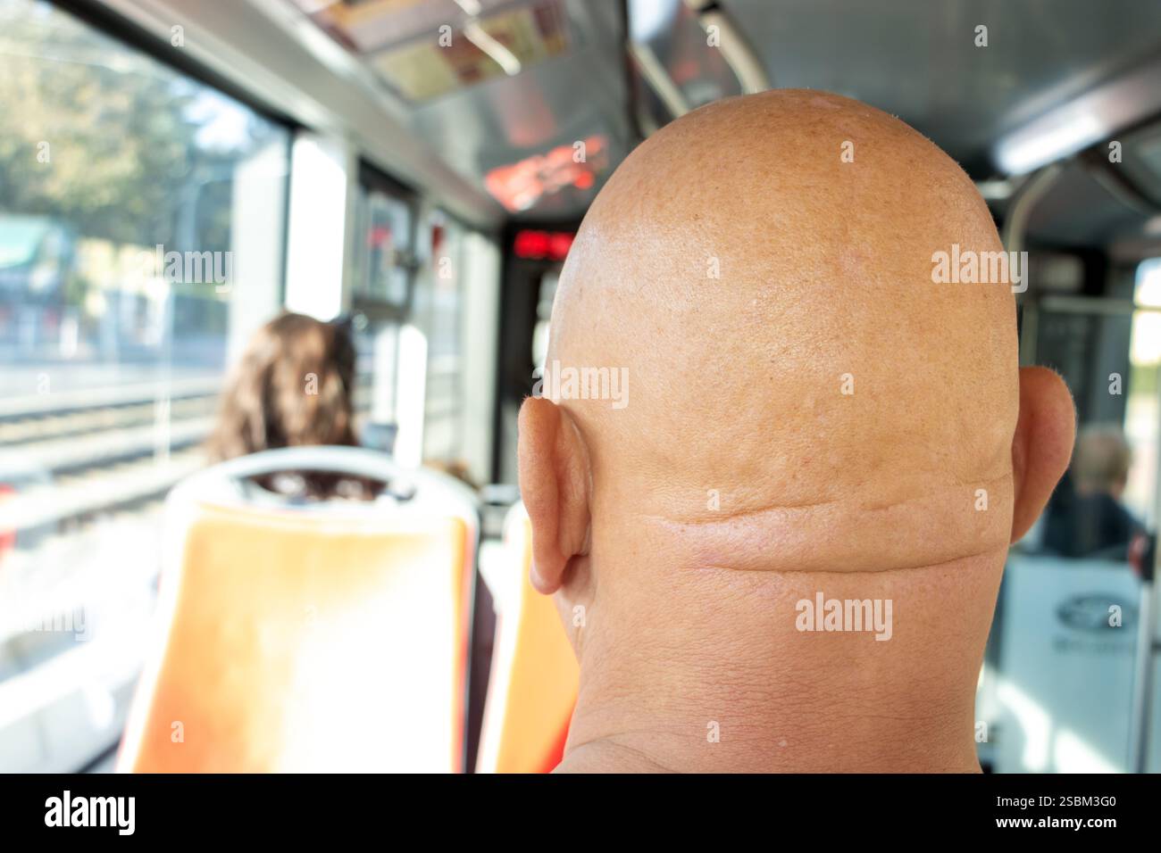 Capo di un passeggero calvo su un autobus cittadino Foto Stock