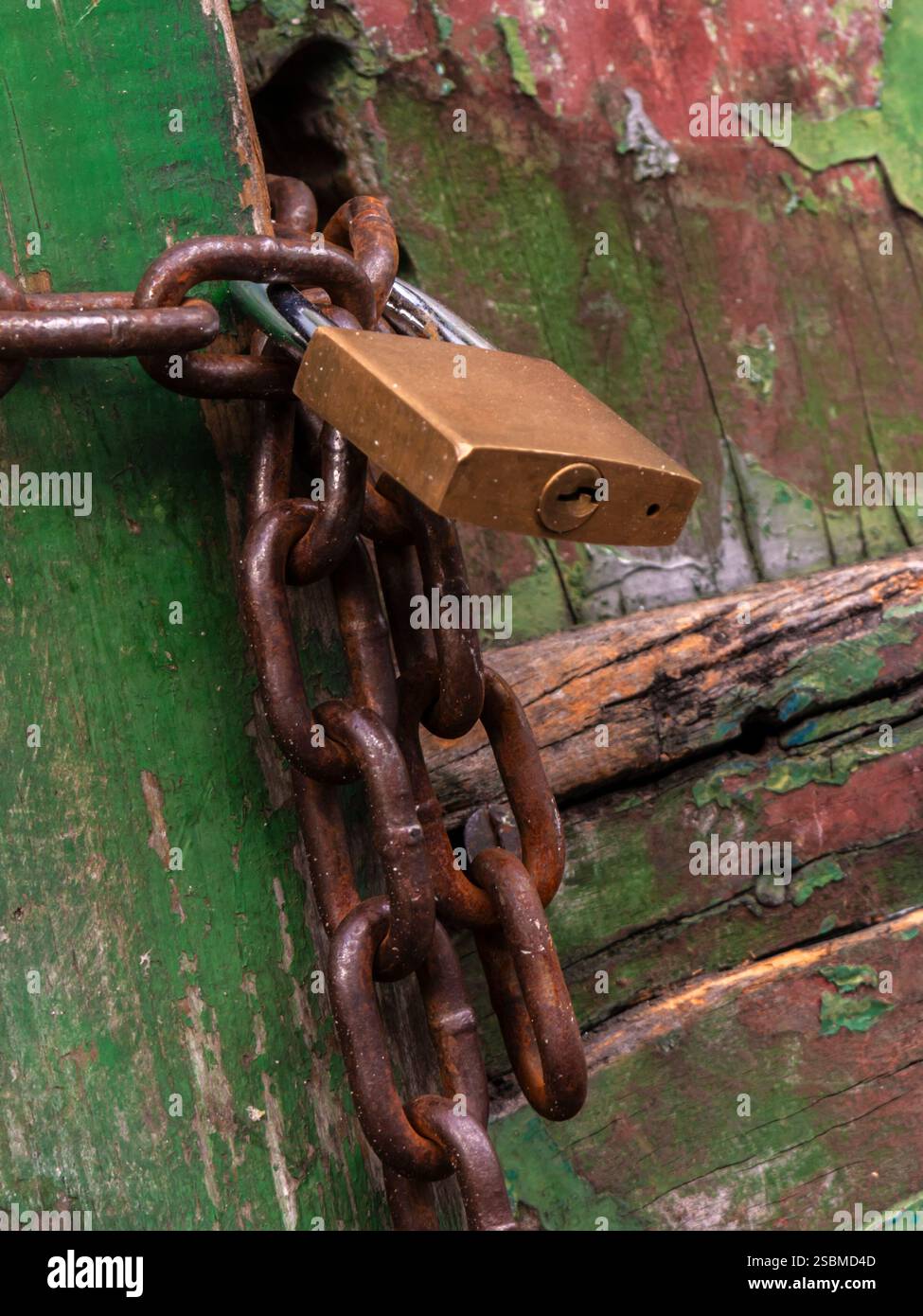 Il lucchetto chiude il cancello di legno con una catena arrugginita, in Brasile Foto Stock