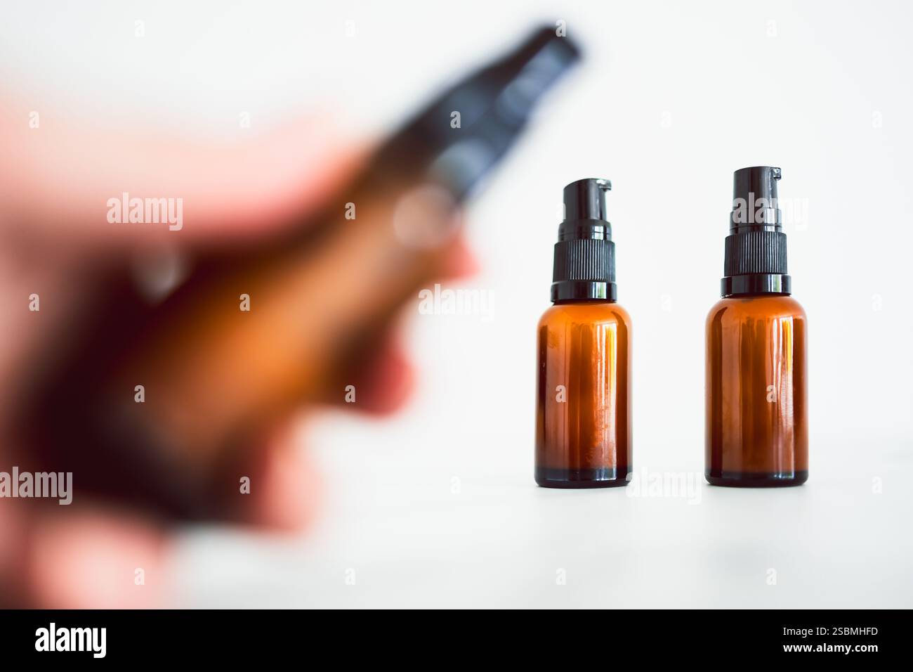idratanti per siero oculare identici con flacone in stile ambrato farmacista su sfondo minimalista in marmo bianco Foto Stock