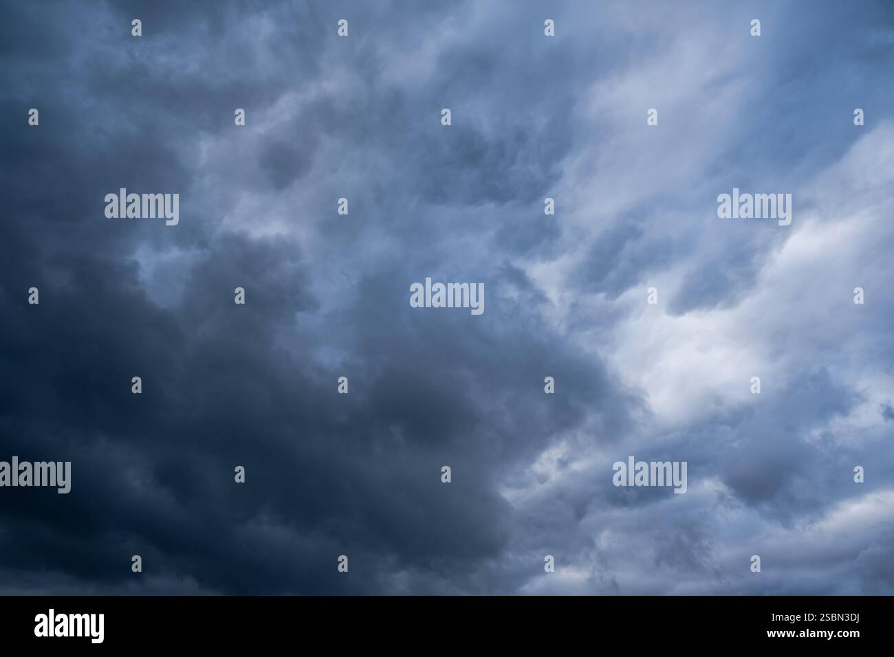 La vista ipnotizzante di un cielo piovoso pieno di nuvole scure e scoscese crea un forte senso di dramma e tensione atmosferica, rendendolo la scelta ideale per temi legati ai fenomeni meteorologici Foto Stock
