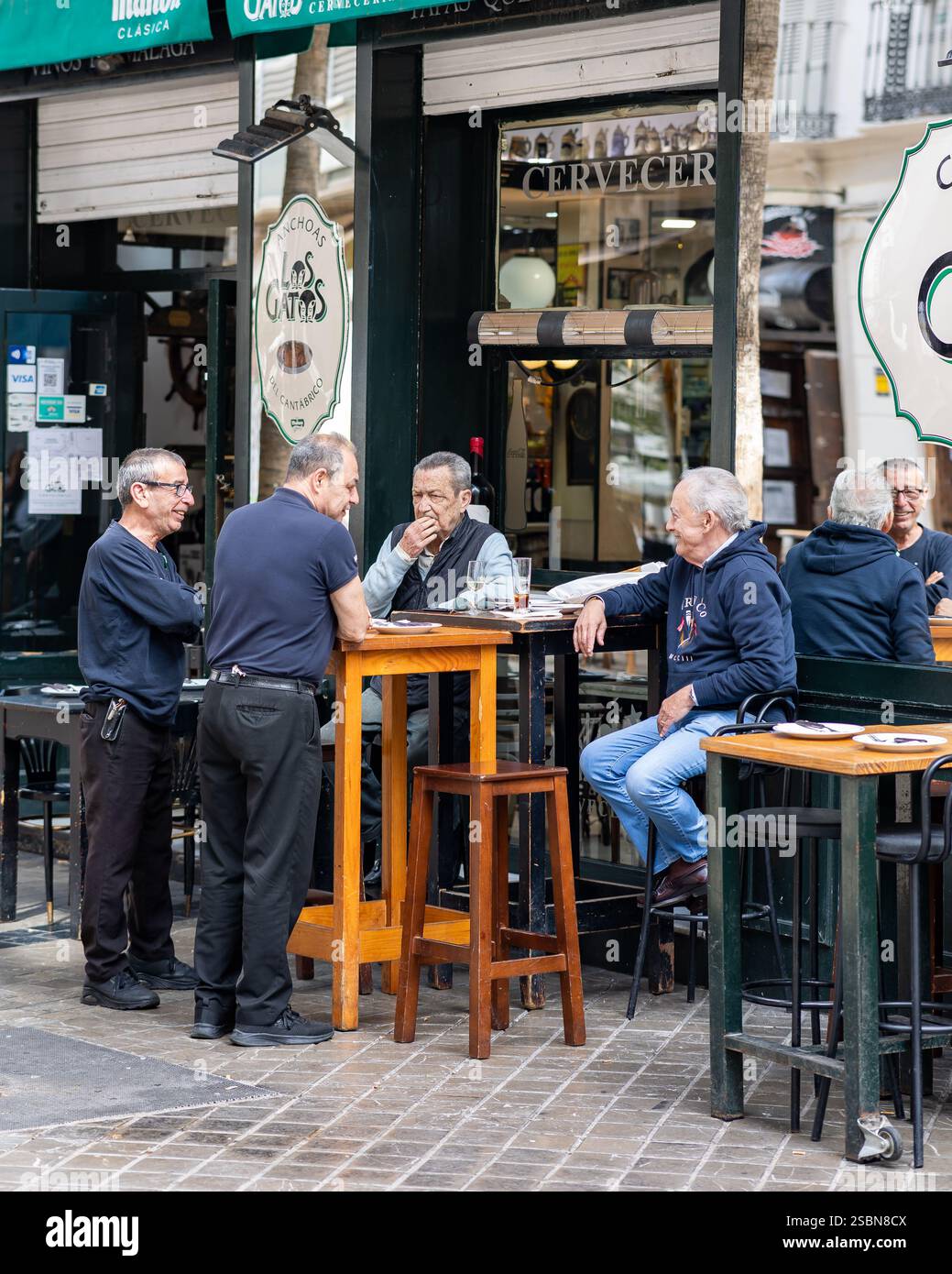 Amici che bevono un drink in una terrazza nel centro storico di Malaga Foto Stock