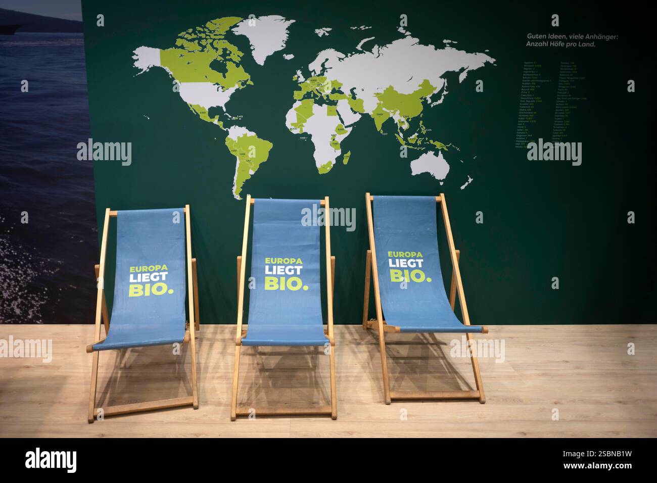 Gruene Woche Berlin DEU, Deutschland, Germania, Berlino, 23.01.2025 Liegestuehle mit motto Europa liegt Bio MIT Bio Die Welt verandern am Stand Grenzenlos Regional Bio in Europa und Naturland zum Thema oekologische Landwirtschaft in der Biohalle vom Forum moderne Landwirtschaft auf der Messe der Internationalen Woche unter dem Land Gutes Essen Startsland Deutschaft in Berlin. Die Internationale Gruene Woche Berlin ist eine internationale Verbrauchermesse und Ausstellung der Ernaehrungswirtschaft Gartenbau und fuer landwirtschaftliche Produ Foto Stock