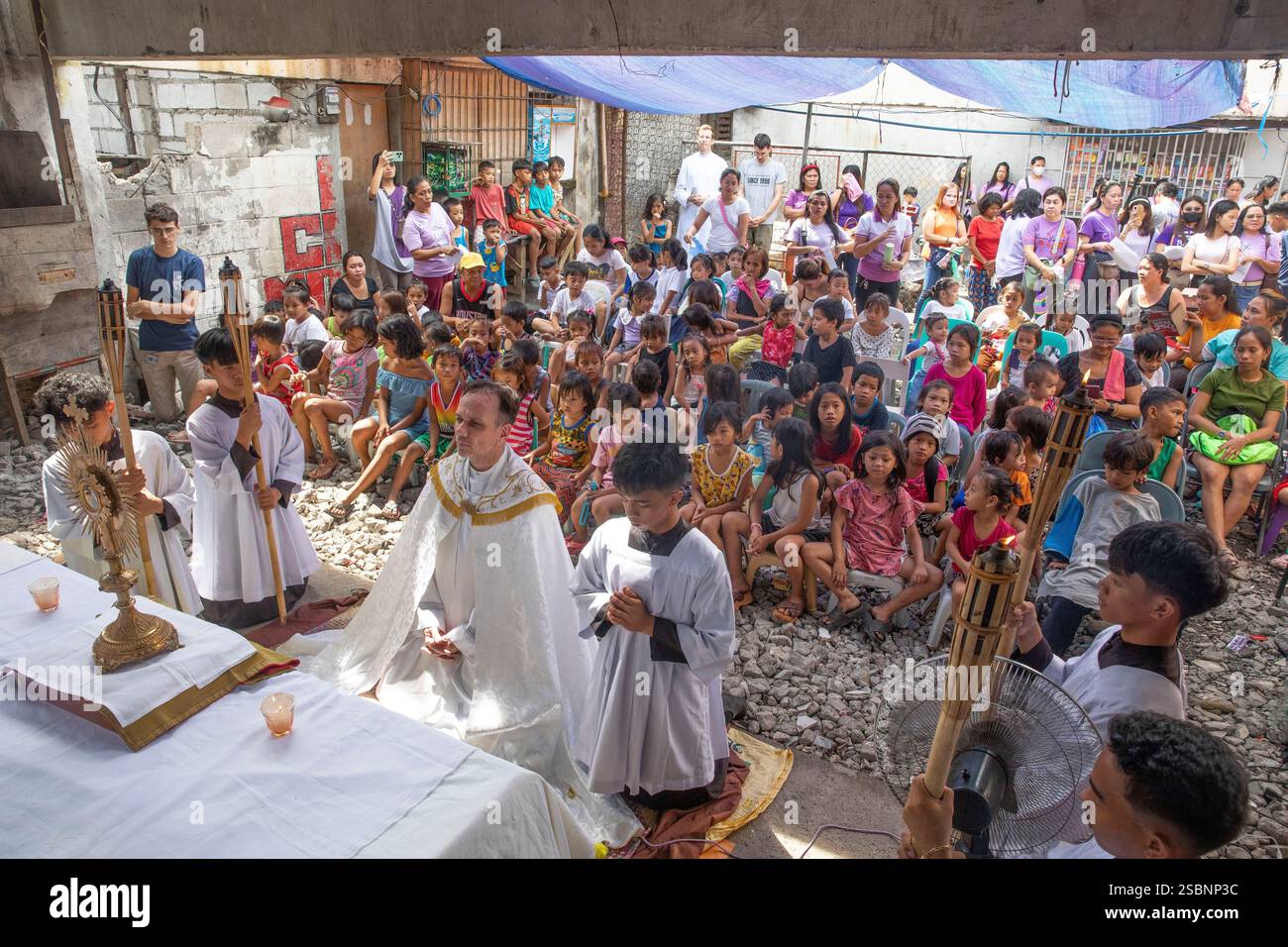 Filippine, Manila, Jundo, Matthieu Dauchez, sacerdote francese a capo della fondazione Anak-TNK, che aiuta i bambini di strada, celebrando la messa per i bambini di strada dopo una processione in una baraccopoli, croce processionale in mano Foto Stock Filippine, Manila, Jundo, Matthieu Dauchez, sacerdote francese a capo della fondazione Anak-TNK, che aiuta i bambini di strada, celebrando la messa per i bambini di strada dopo una processione in una baraccopoli, croce processionale in mano Foto Stock