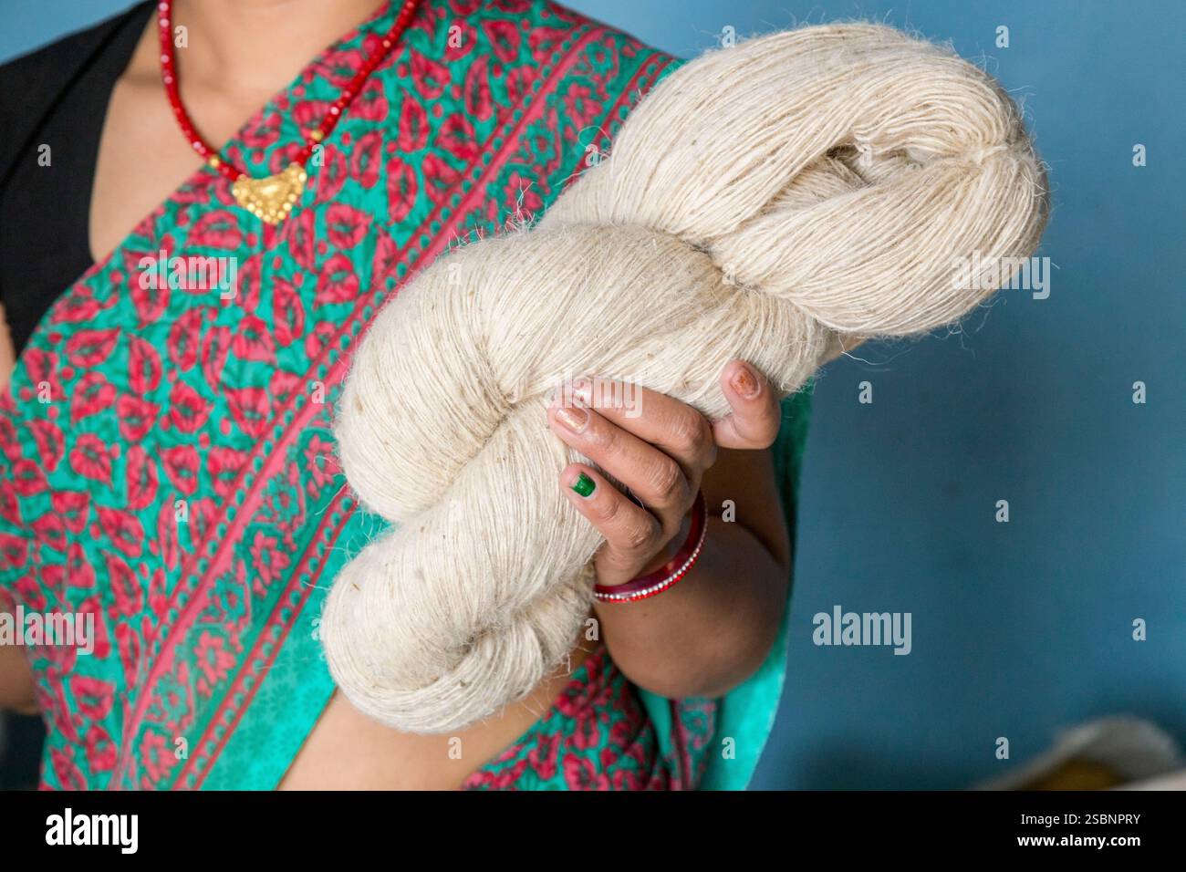 Nepal, Chitwan, donna che mostra lana prodotta localmente Foto Stock