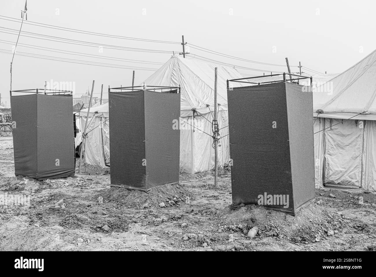 La latrina di nuova costruzione si erge fuori dalle tende di Kumbh Mela, garantendo servizi igienici essenziali per i pellegrini in mezzo al grande raduno. Foto Stock