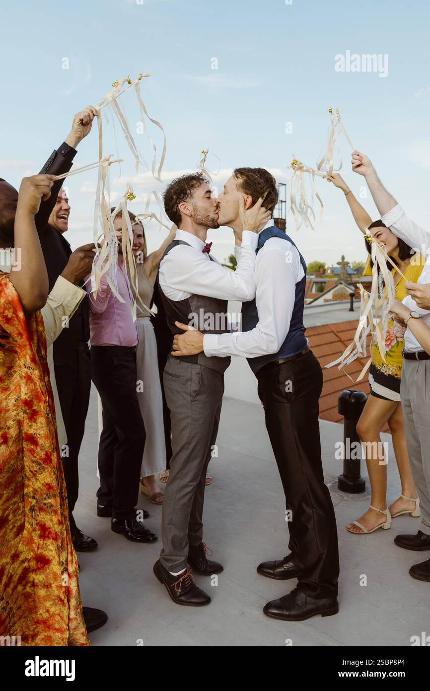 Romantica coppia gay che si baciano durante la cerimonia di nozze Foto Stock