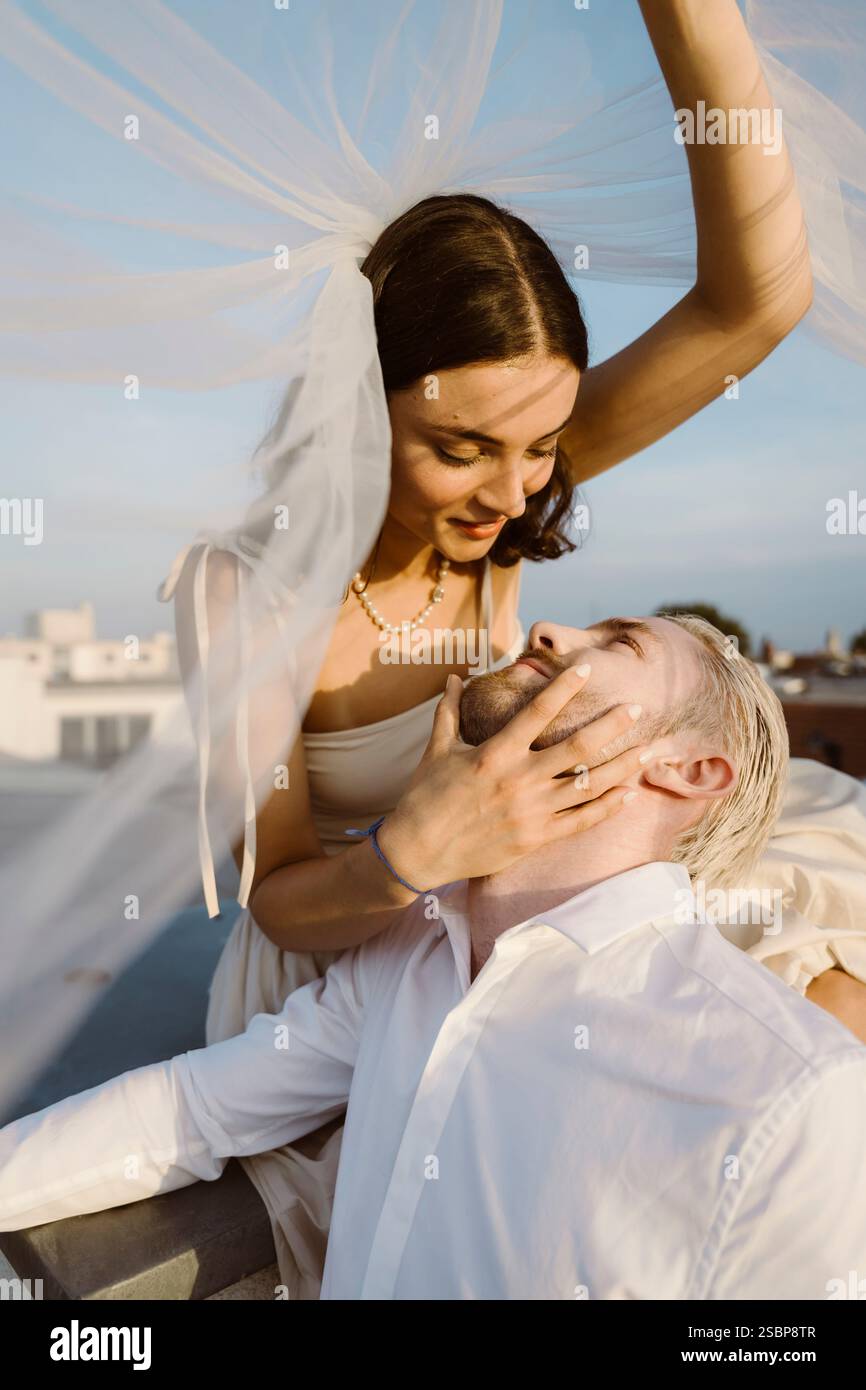 Romantica giovane coppia sposata sotto velo Foto Stock
