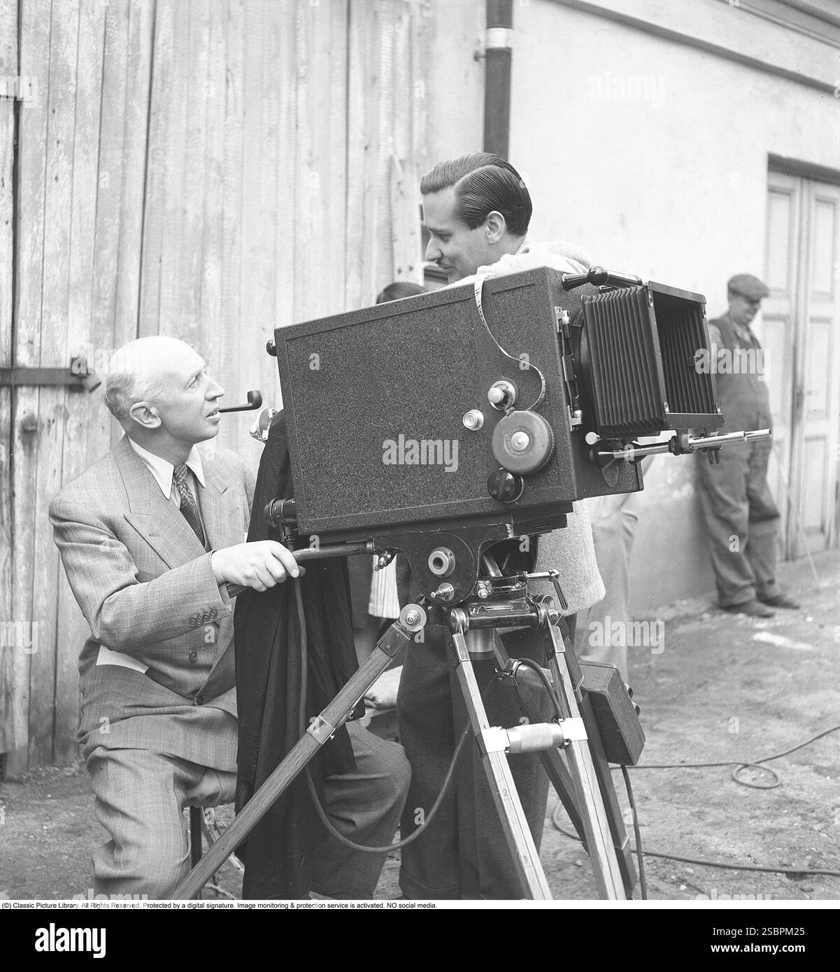 Olof Molander. Regista svedese, (1892-1966). Qui con Lorens Marmstedt, (1908-1966), durante le riprese del film Lyckan kommer. Si trovano accanto a una telecamera montata su un treppiede. 1942. Kristoffersson rif. H23-2 Foto Stock Olof Molander. Regista svedese, (1892-1966). Qui con Lorens Marmstedt, (1908-1966), durante le riprese del film Lyckan kommer. Si trovano accanto a una telecamera montata su un treppiede. 1942. Kristoffersson rif. H23-2 Foto Stock