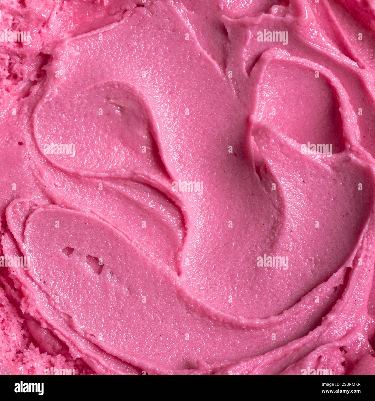 Consistenza del gelato ai frutti di bosco rosa come sfondo. Primo piano di yogurt congelato alla fragola e lamponi. Foto Stock