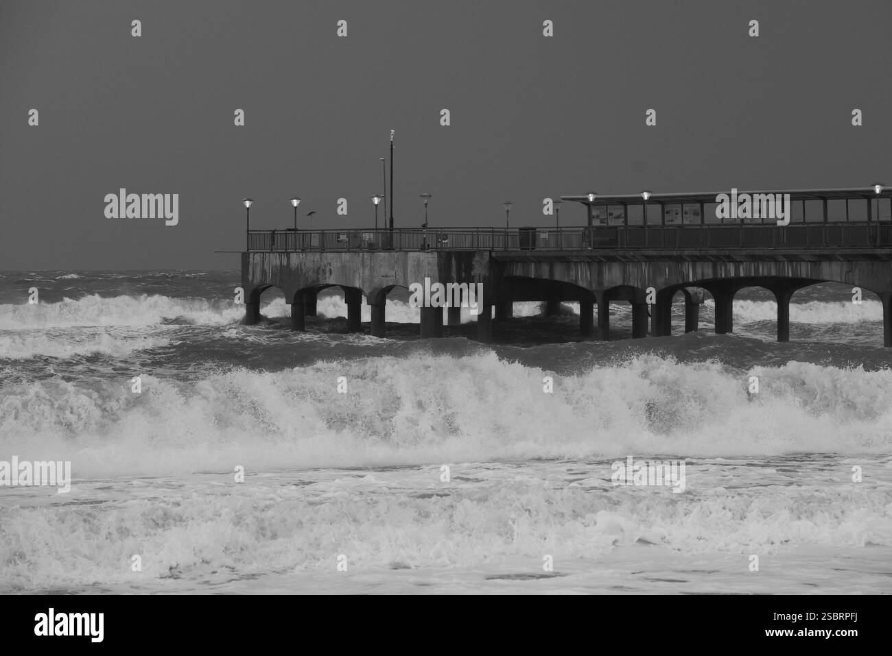 Boscombe Pier, Dorset, Inghilterra, Regno Unito in tempesta durante la tempesta Herminia. Bianco e nero. Foto Stock