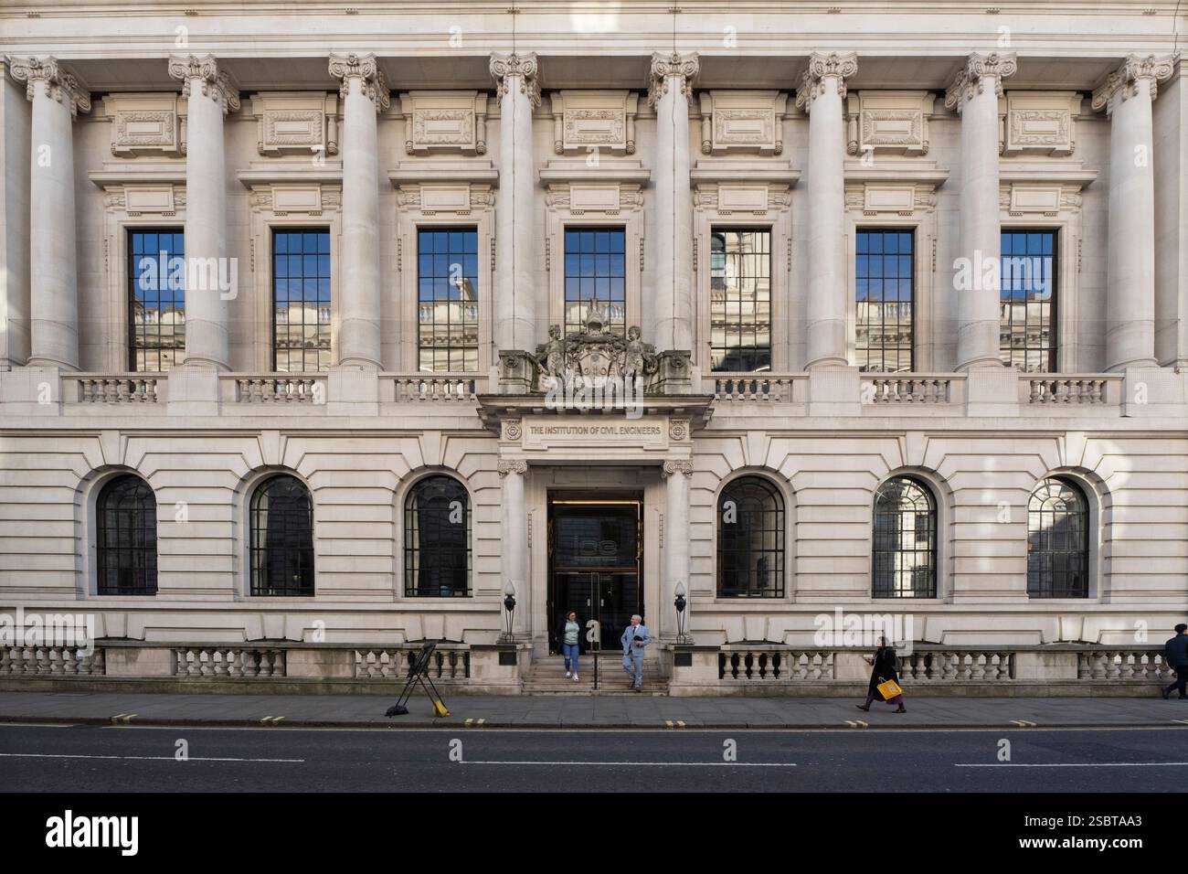 I pedoni passano davanti all'edificio Institution of Civil Engineers. Persone che escono dall'edificio. Foto Stock