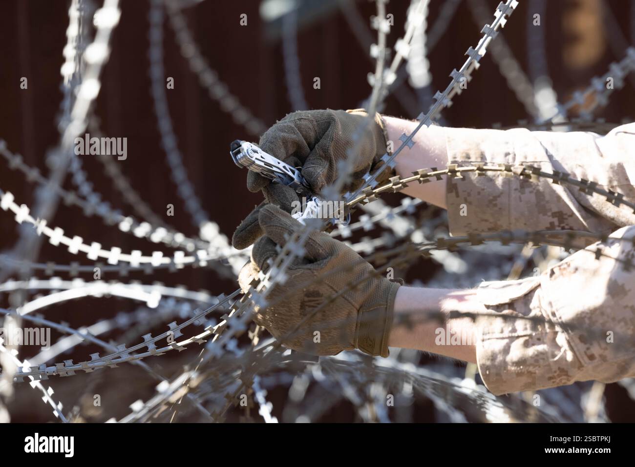 Un Marine degli Stati Uniti con il 1st Combat Engineer Battalion, la 1st Marine Division, regola il filo a fisarmonica lungo il muro di confine meridionale vicino a San Ysidro, California, 3 febbraio 2025. Il comando del Nord degli Stati Uniti sta collaborando con il Dipartimento per la sicurezza interna con l'installazione di barriere fisiche per aggiungere ulteriore sicurezza che limiterà i valichi di frontiera illegali. (Foto del corpo dei Marines degli Stati Uniti di Lance Cpl. Caleb Goodwin) Foto Stock