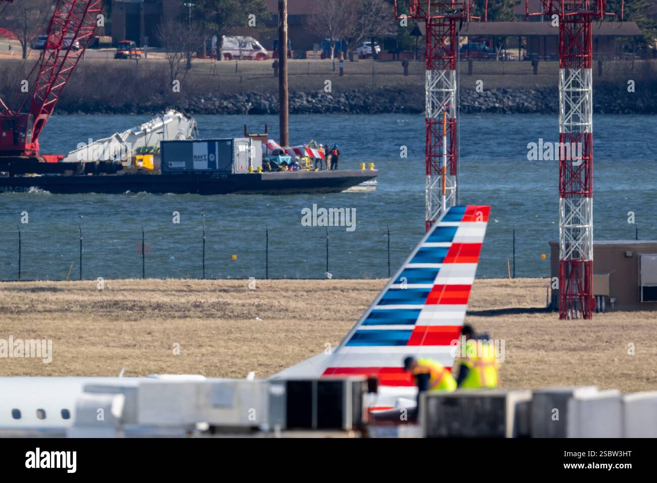 Parts of a plane are lifted from the water near the wreckage site in ...