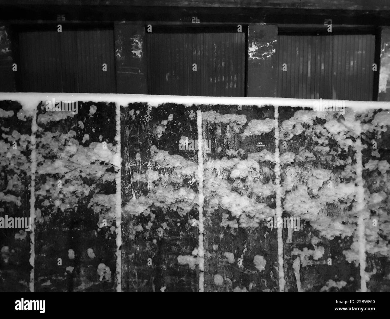 Muro coperto con porte del garage numerate. Di notte. Foto Stock