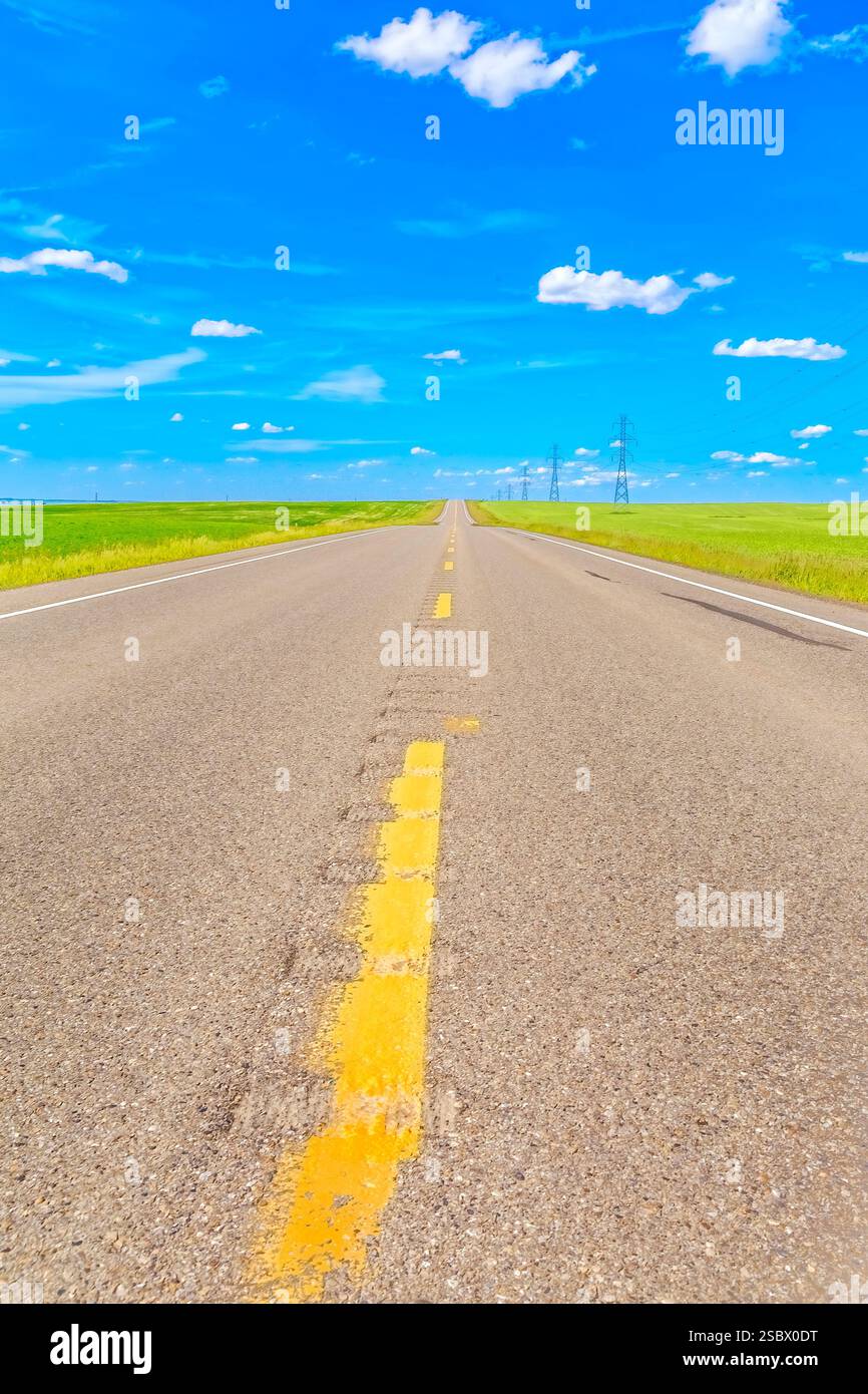 Strada con linee gialle e un cielo blu. Non ci sono auto sulla strada Foto Stock