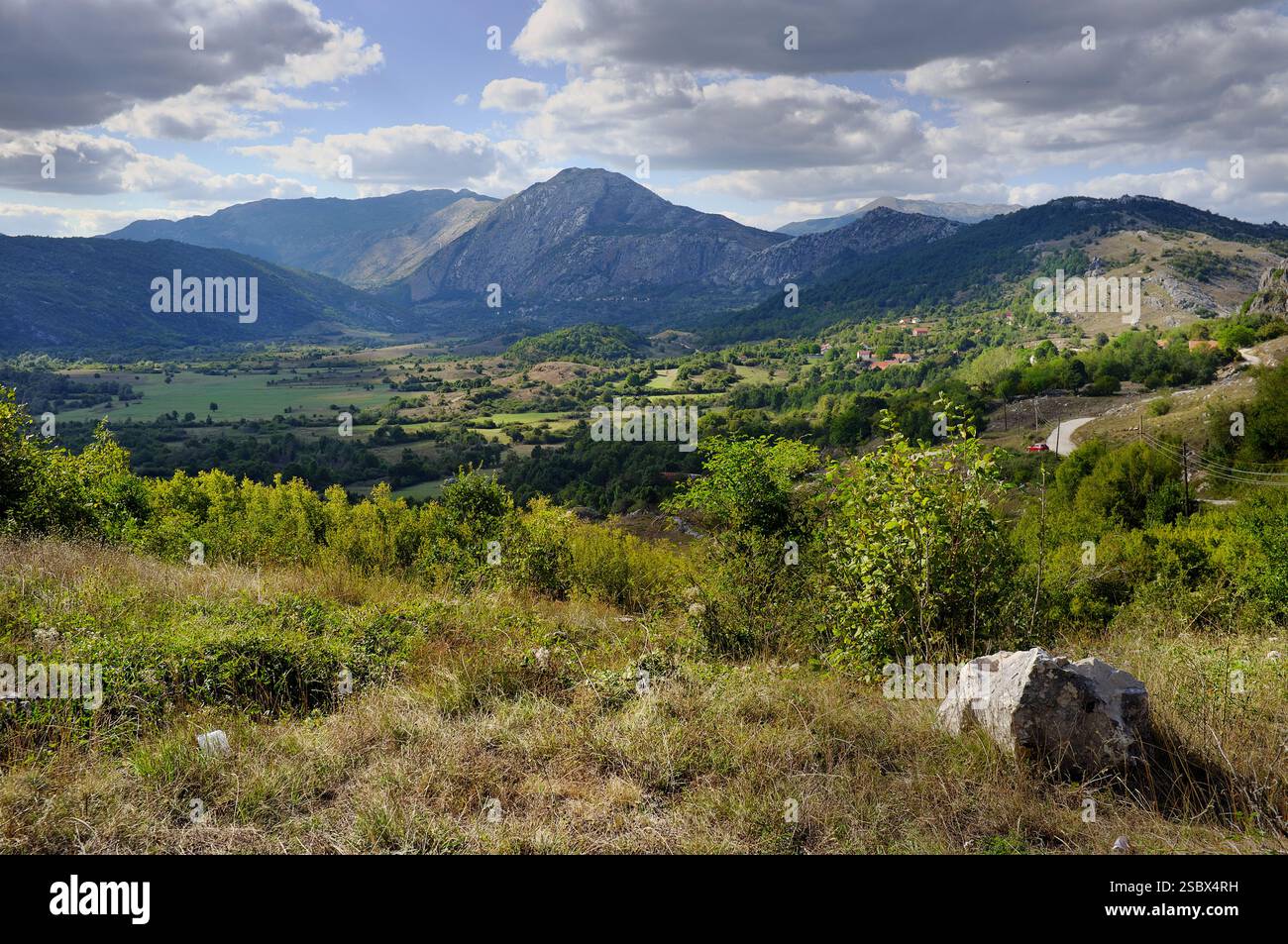 Splendido paesaggio rurale di campi con boschi e Baba Mountain (1.737 m) sulla strada per Kljuc, Gacko, Bosnia ed Erzegovina Foto Stock