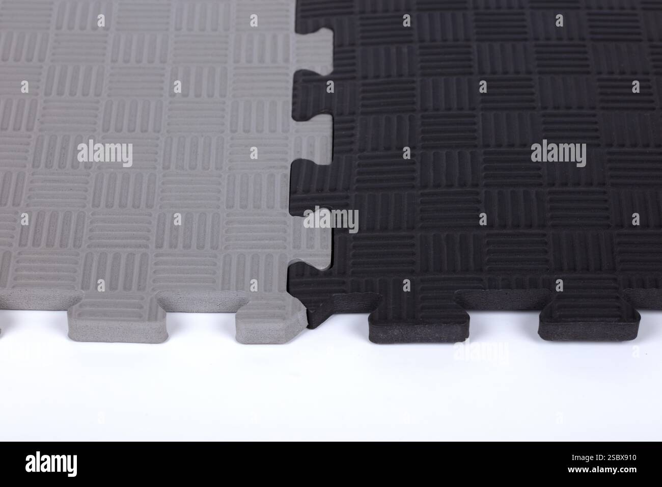 Tappetini in schiuma EVA grigi e neri a incastro - piastrelle da pavimento resistenti per palestre, esercizi e imbottiture di sicurezza Foto Stock