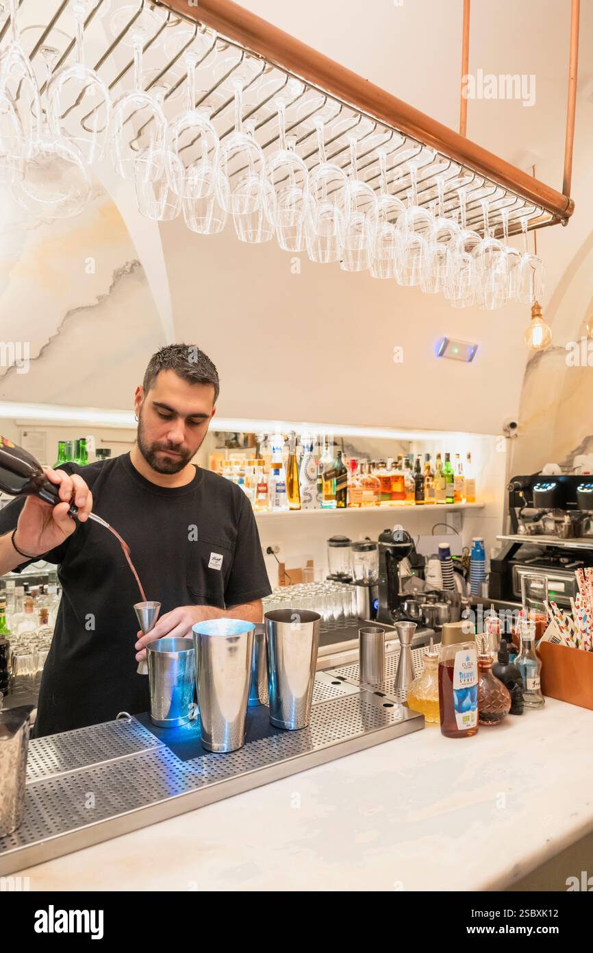 Un barista greco mescola un drink al bancone dell'Hassapiko Bar di Oia, Santorini, Grecia Foto Stock
