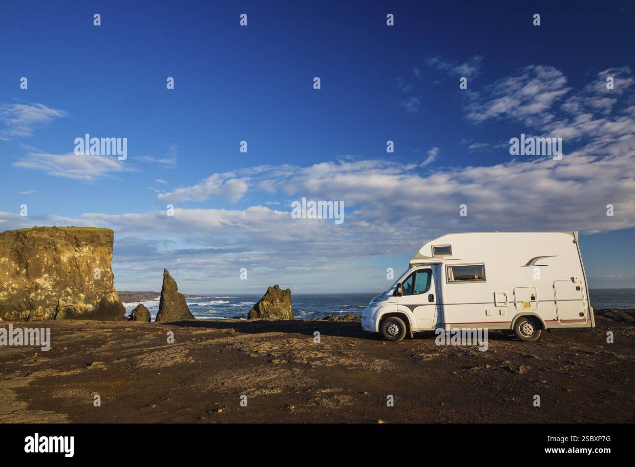 Parcheggio per camper sulla costa, a sud di Sandvik con onde che si infrangono. Natura ruvida Foto Stock