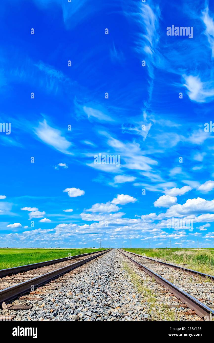Binario del treno con un cielo blu sullo sfondo. Il cielo è limpido e nuvoloso Foto Stock