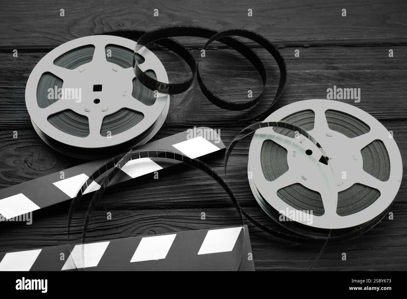 Clapper e film su un tavolo in legno nero, sopra la vista Foto Stock