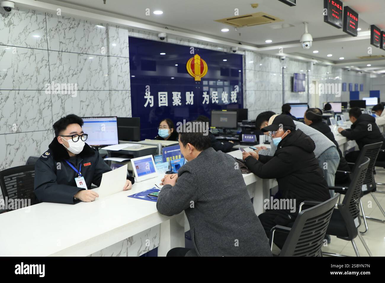 YANCHENG, CINA - 5 FEBBRAIO 2025 - Un membro del personale del centro di servizio per gli affari governativi gestisce le attività connesse per le masse nella contea di Funing, Foto Stock