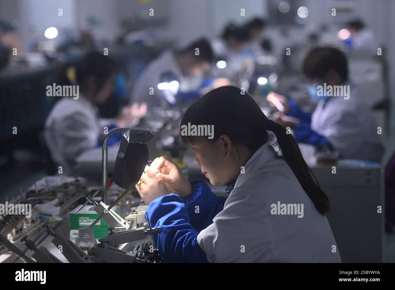 HANGZHOU, CINA - 5 FEBBRAIO 2025 - lavoratori qualificati producono lenti endoscopiche mediche per l'esportazione negli Stati Uniti presso l'officina di produzione di AN Foto Stock