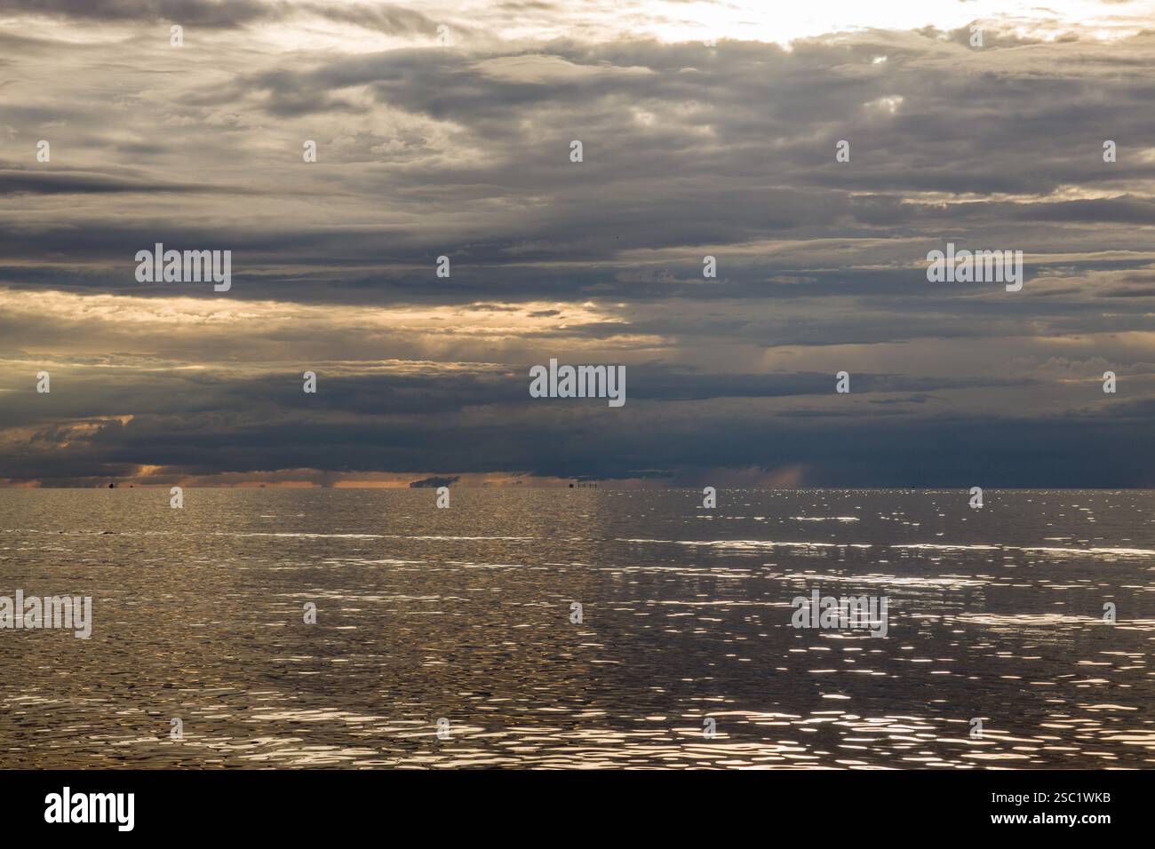 Spettacolare paesaggio marino con nuvole testurizzate e acqua scintillante. Ambientazione suggestiva e piena di atmosfera con accenni di luce che si infrangono. Perfetto per la natura, tra Foto Stock