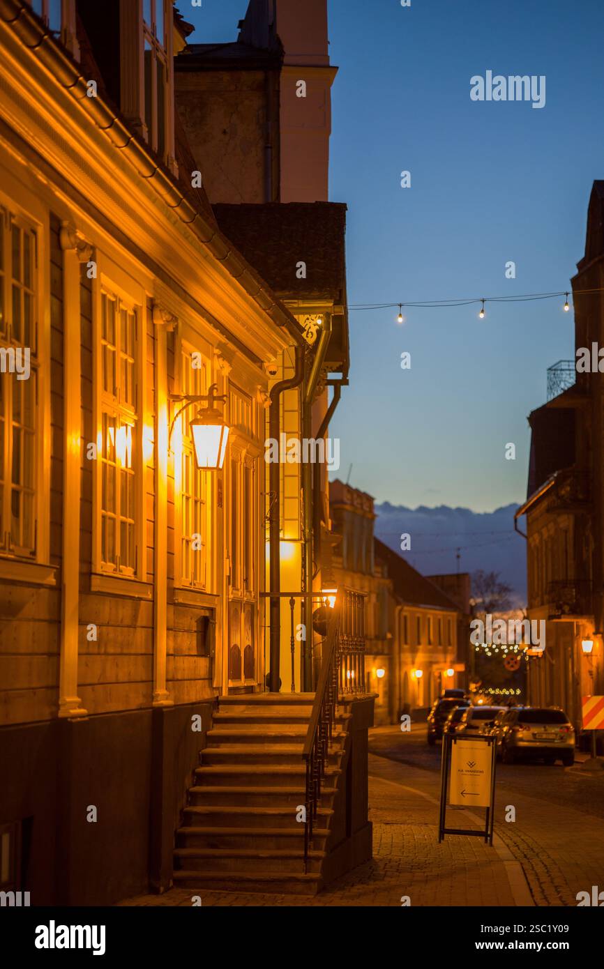 Affascinante scena di strada a Cesis, Lettonia al crepuscolo. Edifici storici con luci calde creano un'atmosfera accogliente in questa città vecchia. Perfetto per i viaggi, Foto Stock