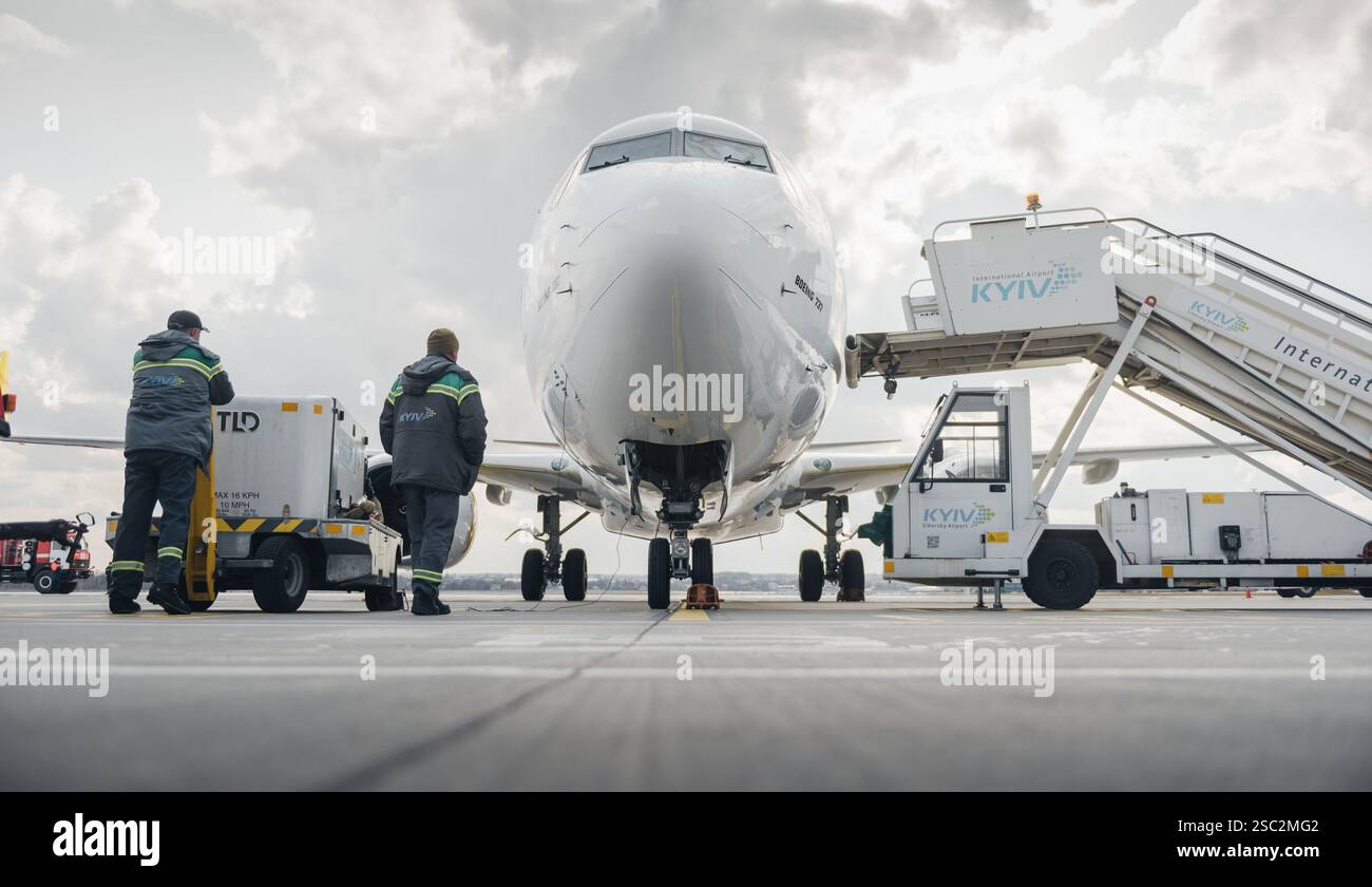 Boeing 737-800 in fase di preparazione per lo sbarco e lo scaricamento dei bagagli. Vista frontale ad angolo basso delle Bees Airline (UR-UBA) parcheggiate sul grembiule. Foto Stock