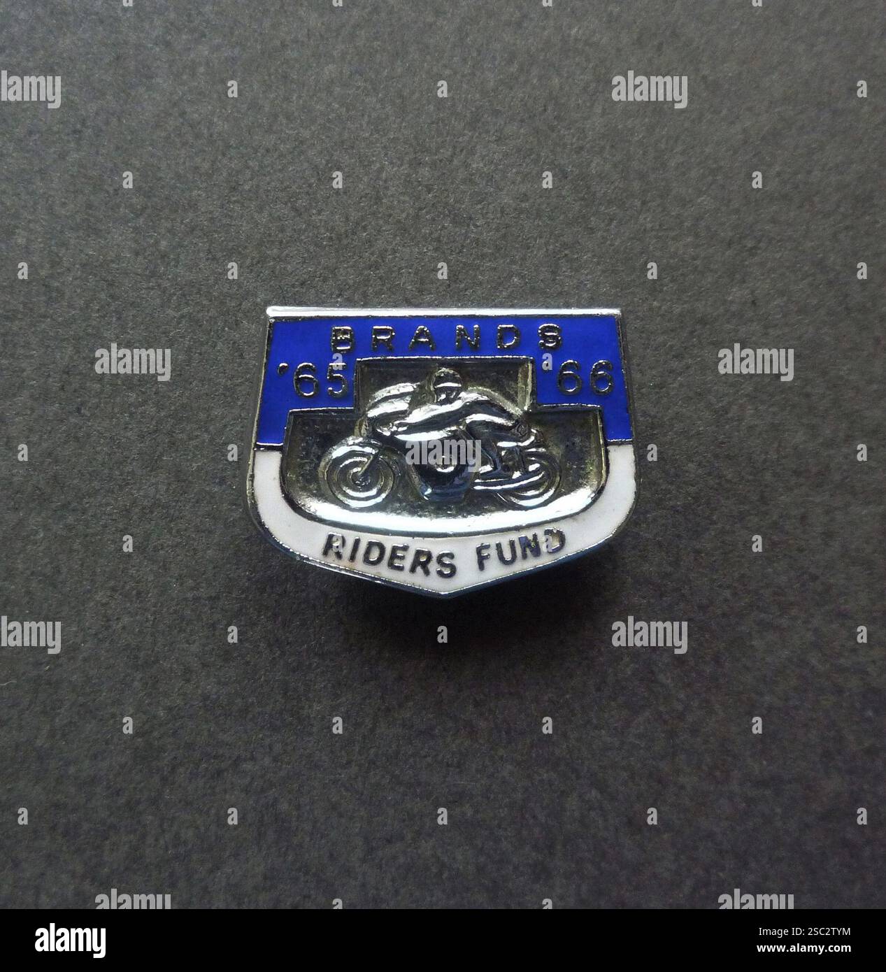Un badge vintage smaltato Brands Riders Fund '65-'66 prodotto per la stagione 1965-1966 per raccogliere fondi per il Fondo Benevolent di Brands Hatch Riders. Questa associazione di beneficenza è stata fondata per offrire supporto e assistenza ai motociclisti che erano stati gravemente feriti in gara al circuito automobilistico di Brands Hatch a West Kingsdown, Kent, Inghilterra. Foto Stock