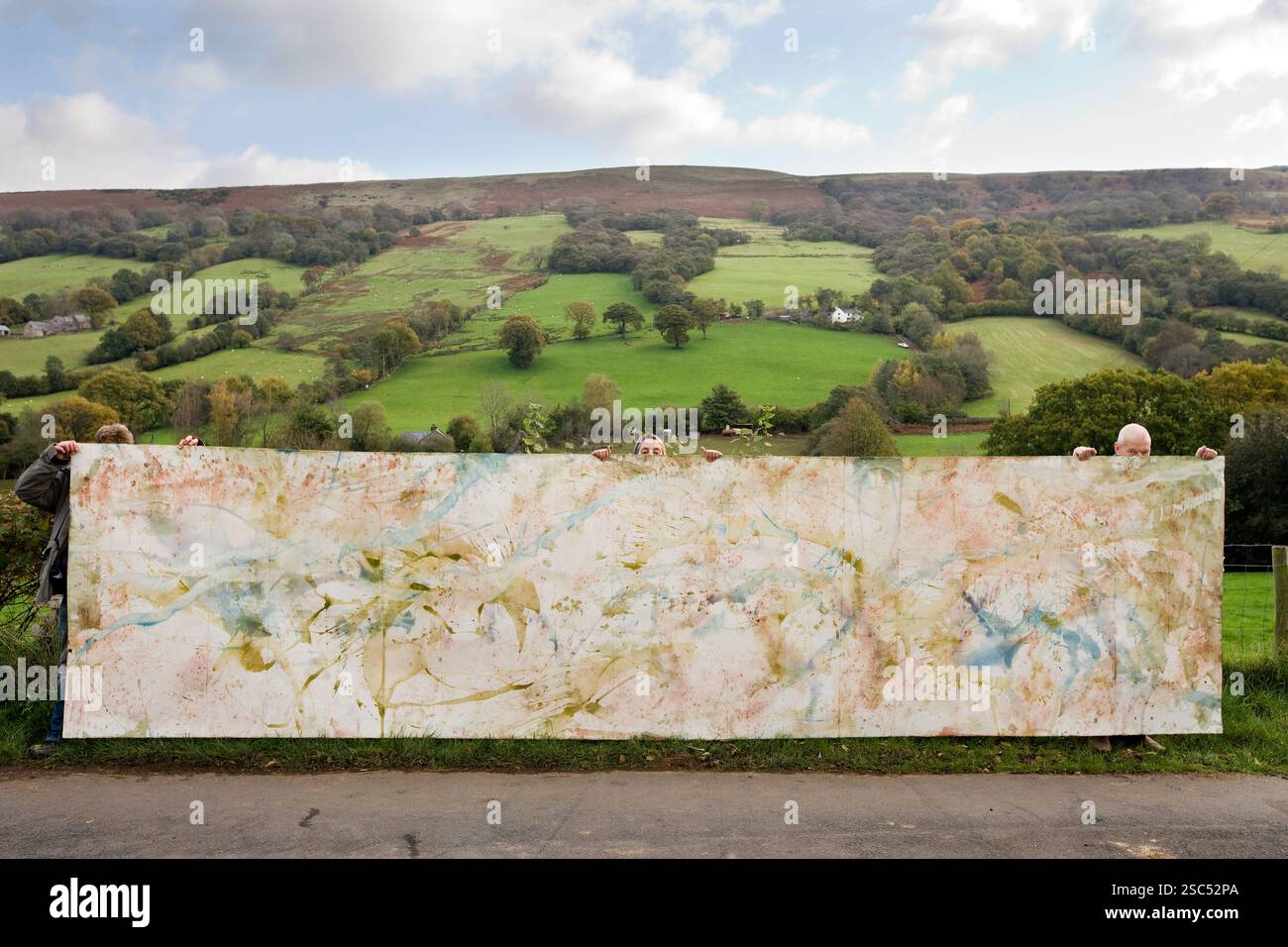 PIP Woolf e due aiutanti portano una grande opera d'arte che ha realizzato, da fotografare prima di essere tagliata per il suo progetto di libro sull'acqua. Ha usato l'acqua del suo sistema idrico per disegnare sulla carta pesante. (Ulteriori informazioni a seguire) foto di Mike Goldwater Foto Stock