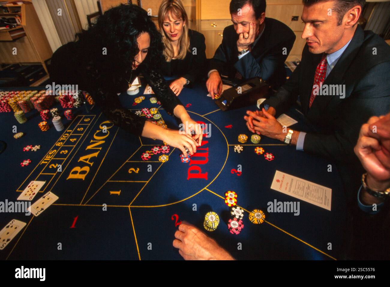Un gruppo di persone che giocano a carte in un tavolo da casinò a Beruit, Libano, con varie chip di scommesse visibili. Foto Stock