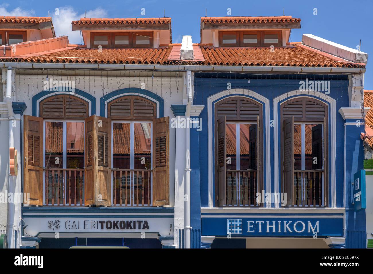 I tradizionali tetti di tegole rosse delle botteghe di North Bridge Road si riflettono nelle finestre delle botteghe di fronte. Foto Stock