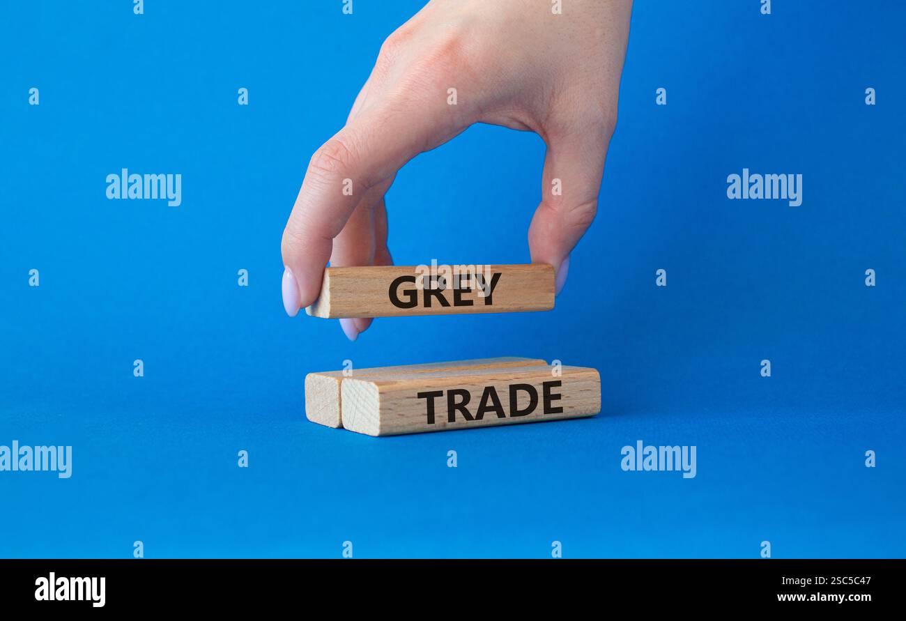 Simbolo commerciale grigio. Blocchi di legno con parole "commercio grigio". Bellissimo sfondo blu. Mano d'affari. Business e concetto di commercio grigio. Copia spazio. Foto Stock