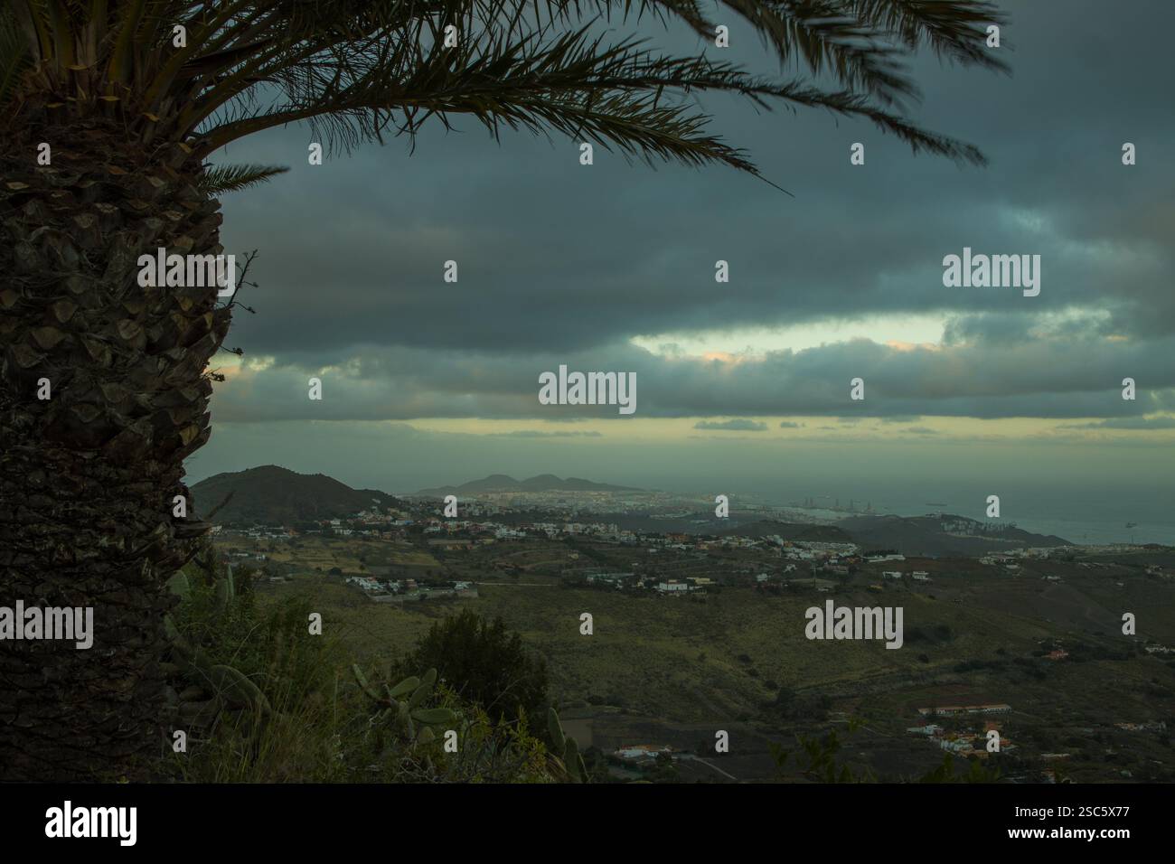 Paesaggio montuoso a Gran Canaria vicino a Bandama, con una strada tortuosa e un piccolo villaggio. Cielo spettacolare con luce calda all'alba o al tramonto. Perfetto per Foto Stock