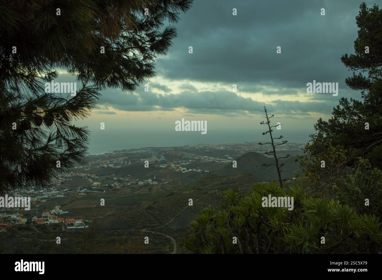 Paesaggio montuoso a Gran Canaria vicino a Bandama, con una strada tortuosa e un piccolo villaggio. Cielo spettacolare con luce calda all'alba o al tramonto. Perfetto per Foto Stock
