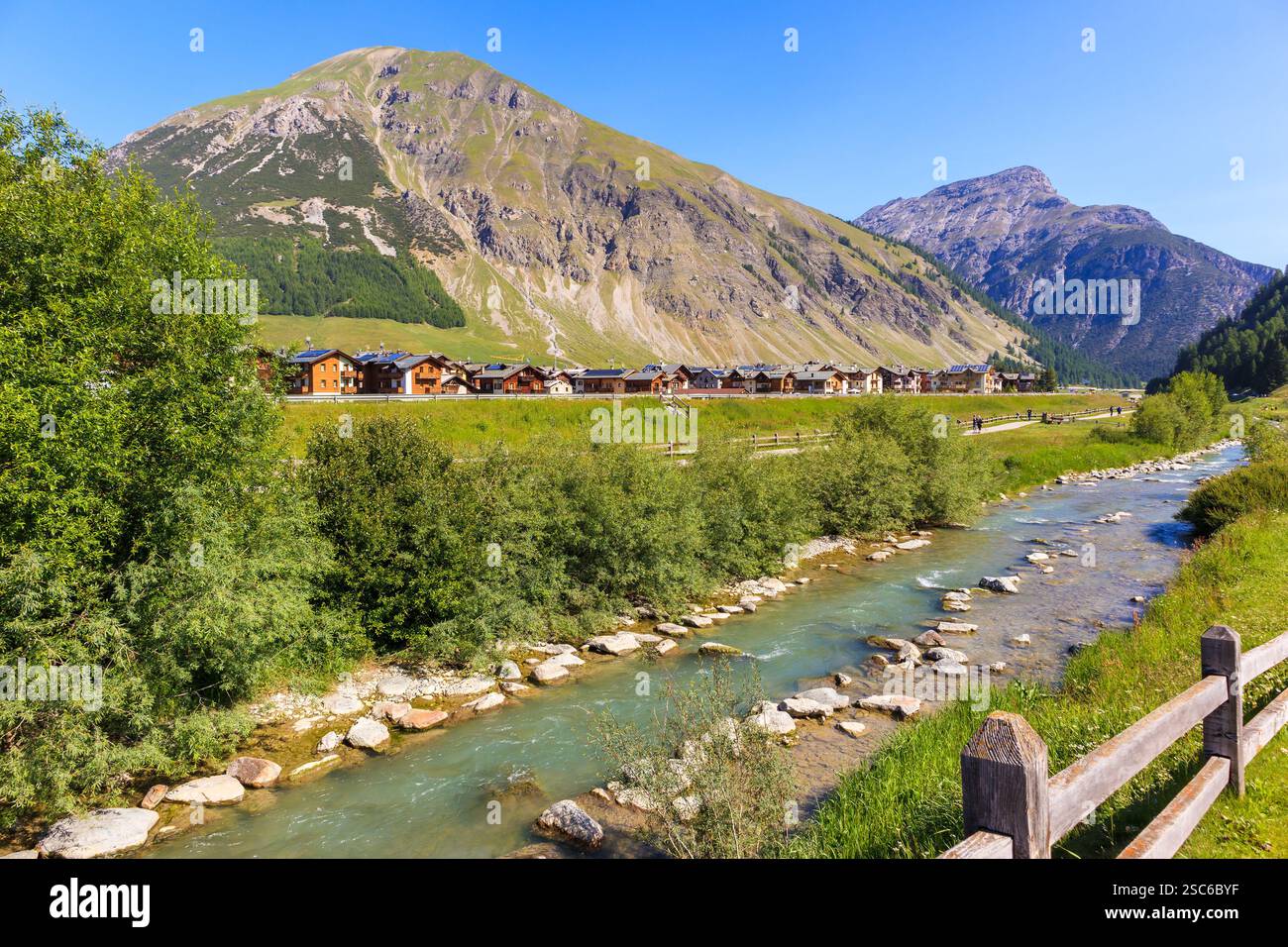 Case nel villaggio di Livigno nelle soleggiate giornate estive, Alpi, Italia Foto Stock