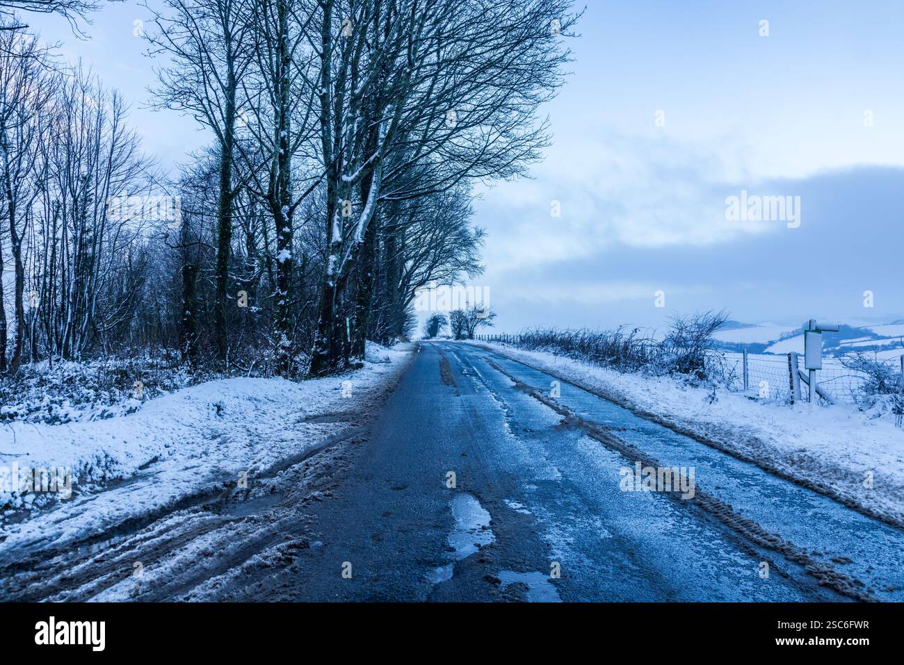 Una vista su una strada rurale del Sussex in una giornata di neve Foto Stock