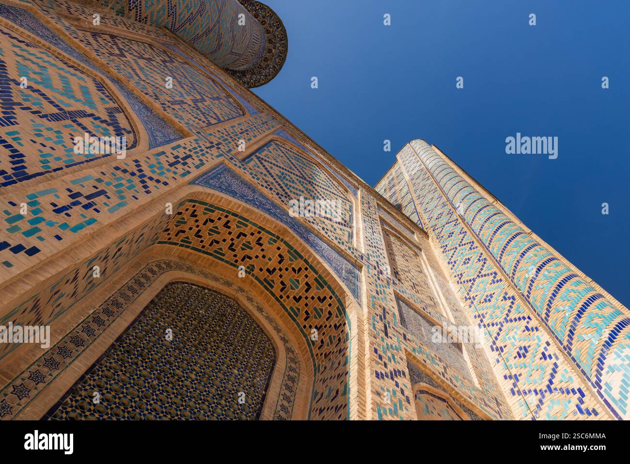 Esterno della Madrasa Ulugh Beg sotto il cielo blu in una giornata di sole, vista prospettica. Piazza Registan, Samarcanda, Uzbekistan Foto Stock